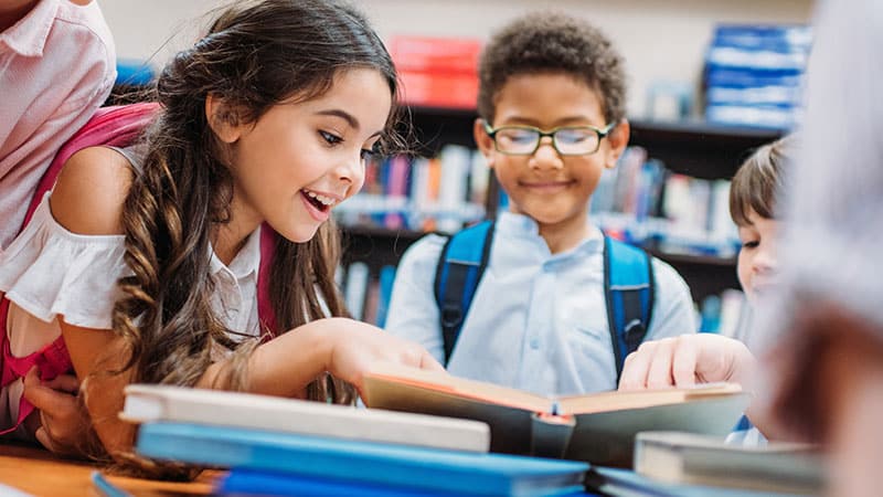 a group of smiling school-age kids study together